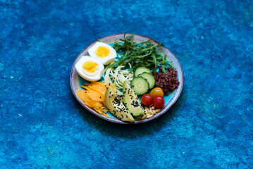 Plate Healhty salad with avocado, egg and fresh vegetables. Сlean eating, top view. Healthy eating concept.