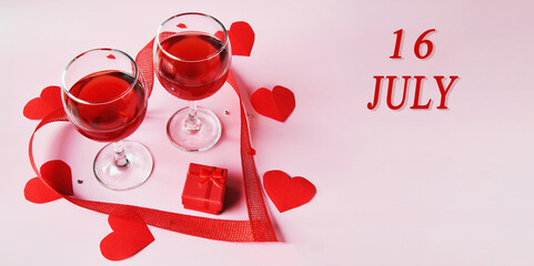 calendar date on light background with two glasses of red wine, red gift box and red hearts with...