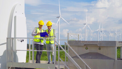Teamwork of Asian windmill engineer group, worker working on site at wind turbines field or farm,...