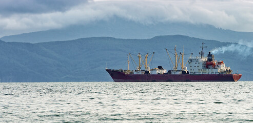 fishing boat in gray morning on Pacific ocean off the coast of the Kamchatka Peninsula