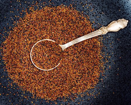 tablespoon in canihua seeds on black plate