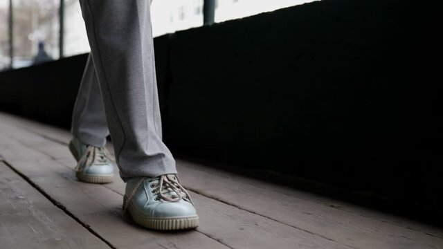 woman is walking over old wooden floor, closeup of feet, casual style for walk in city