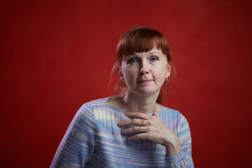 Portrait of adult Caucasian woman on red background