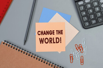 Change the world - concept of text on sticky note. Closeup of a personal agenda. Top view. Office concept