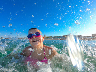 Happy child having fun at the sea .Summer vacation and active lifestyle concept