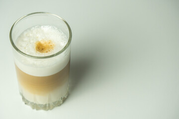 Glass of latte coffee on light background