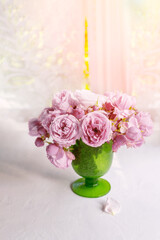 beautiful bouquet of pink peony roses stands on the table against the background of the window. A ray of sunlight shines through the curtains. copy space