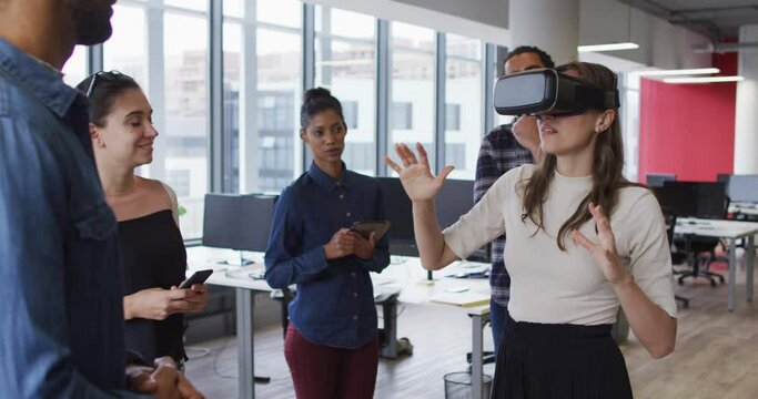 Diverse group of business colleagues using vr headset during meeting