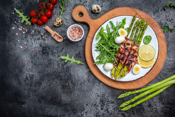 Obraz na płótnie Canvas Bacon wrapped asparagus. Healthy diet food for Keto breakfast. Long banner format, top view