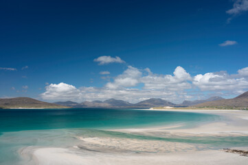 Seilebost and Luskentyre beaches on a bright sunny day with lots of copy space at top. Isle of Harris, Scotland. Taken from high viewpoint. White sand, turquoise and blue sea, mountains.