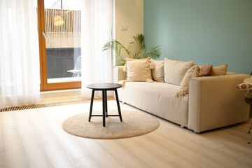 Large bright living room with a sofa with a bright blue wall. Nice interior, apartment