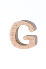 Letter G of the sand isolated in white. summer concept. alphabet.