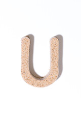 Letter U of the sand isolated in white. summer concept. alphabet.