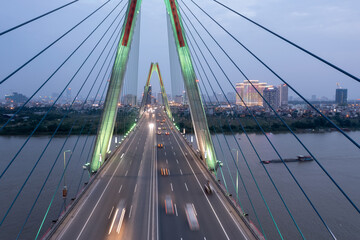 Fototapeta premium Nhat Tan bridge crossing Red River in Hanoi, Vietnam, with blurred vehicles running on the bridge