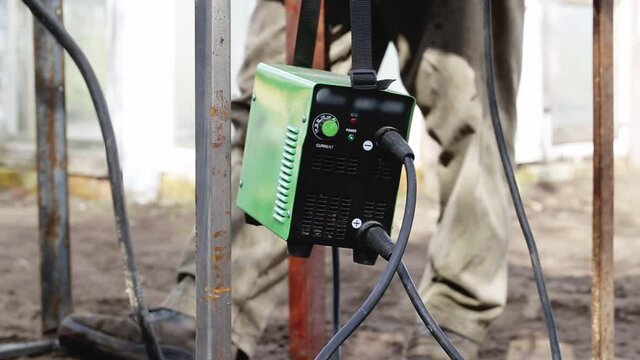 Portable welding machine. Male welder welds metal surfaces, industry