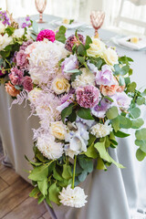 Weddind dinner table decorated with bouquet of flowers.