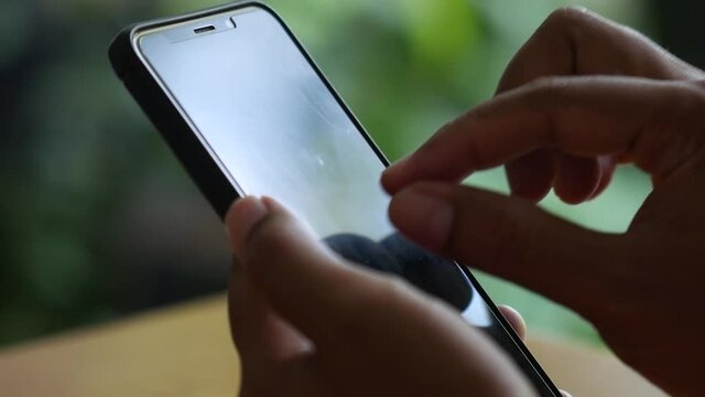 Man hand using a smartphone on table. Gesturing hand on cellular phone