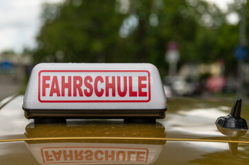 Schild Fahrschule auf dem Dach eines Fahrschulautos 