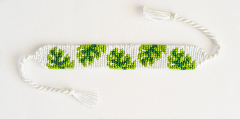 Woven DIY friendship bracelet handmade of embroidery floss with leaves colors