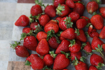 Fresh strawberries in a bowl on wooden table with low key scene