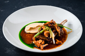 Roasted lamb chops with chanterelles and vegetables on decorated table