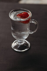 fresh juicy strawberries in a glass of mineral water. Cooling summer drink  