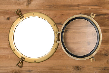Opened brass porthole in rustic wooden wall, opening isolated with clipping path