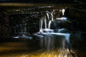 Cascading waterfall cascades in Estonia in green light at summertime