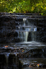 Obraz premium Cascading waterfall cascades in Estonia in green light at summertime