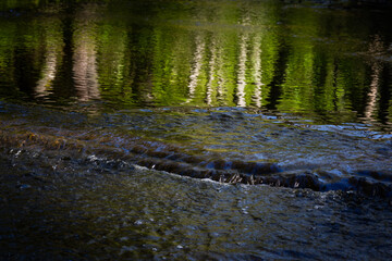 Cascading waterfall cascades in Estonia in green light at summertime