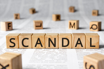 Scandal - word wooden blocks with letters, affray fracas scandal concept, random letters around,...