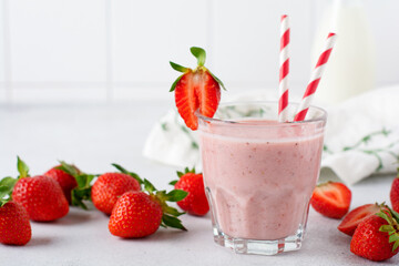Strawberry smoothie or milkshake with berries and oatmeal in glass jar on gray or white concrete background. Vegetarian healthy drink. Close up. Selective focus.