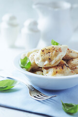 Dumplings with potato and cottage cheese stuffing (pierogi). Traditional Polish Christmas Dinner. Bright background.