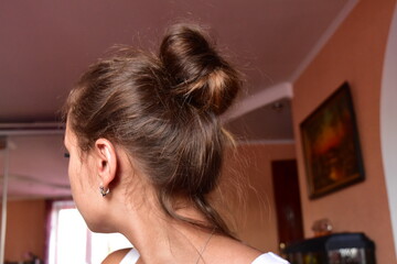 girl with a bun of hair at home