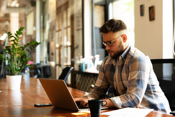 Fototapeta premium Businessman sitting looking at his laptop. Businessman working in the office on his laptop.