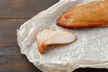 Smoked chicken breast on brown wooden board