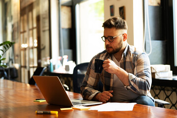 Businessman sitting looking at his laptop. Businessman working in the office on his laptop.