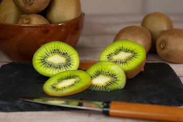 kiwi on a wooden table with wooden knife