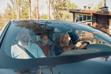 Young happy family with little boy having fun and smiling while driving in the car