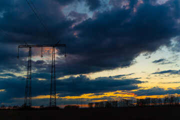 Electric high voltage pole at sunset background