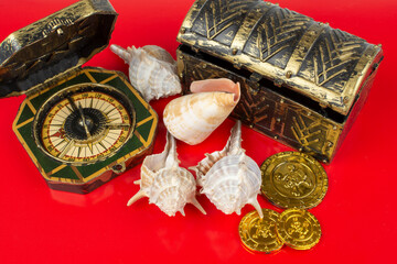 compass and pirate coins on red background