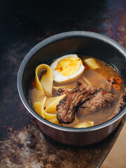 Ramen soup with egg meat brisket noodles on meatl grill
