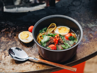 Ramen soup with egg meat brisket noodles on meatl grill