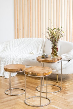 Bouquet of green banches in a glass vase in scandinavian interior on wodden table