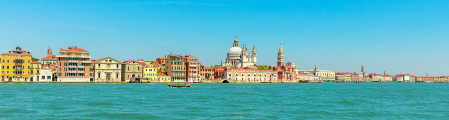 Fototapeta na wymiar Panorama of San Marco bell tower in San Marco square in Venice with Saint Mark Basilica of the famous Venetian city of Italy. sea view from Giudecca canal by cruise boat trip in Venetian lagoon.