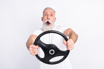 Portrait of attractive cheerful funny man holding in hands steering wheel riding having fun...
