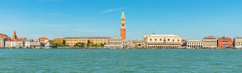 Fototapeta na wymiar Panorama of San Marco bell tower in San Marco square in Venice with Saint Mark Basilica of Venetian city, Italy. sea view from Giudecca canal by cruise boat trip in Venetian lagoon by ferry boat.