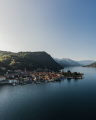 Fototapeta na wymiar Pella city on lake Orta at sunset seen from the sky. Aerial shot of small village on a lake.