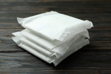 Stack of sanitary pads on wooden background