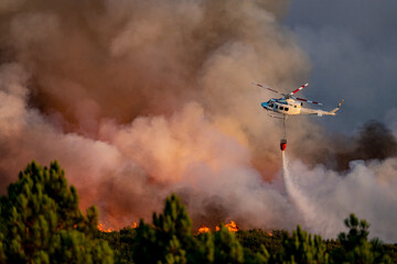 Spectacular helicopter with bambi bucket over the fire